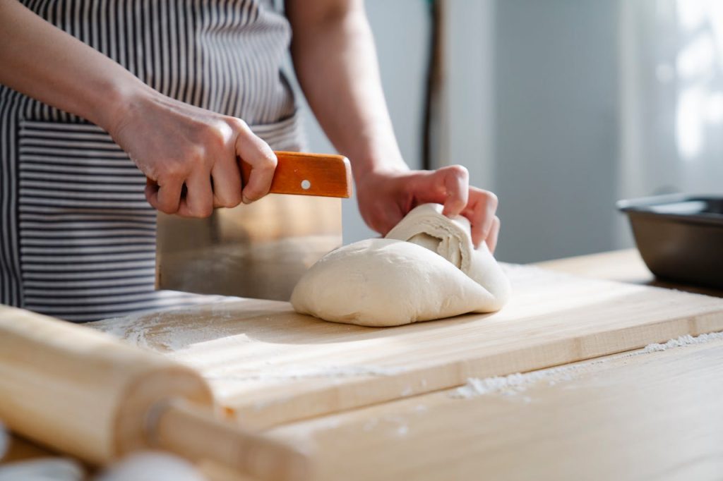 Baker Cutting a Dough